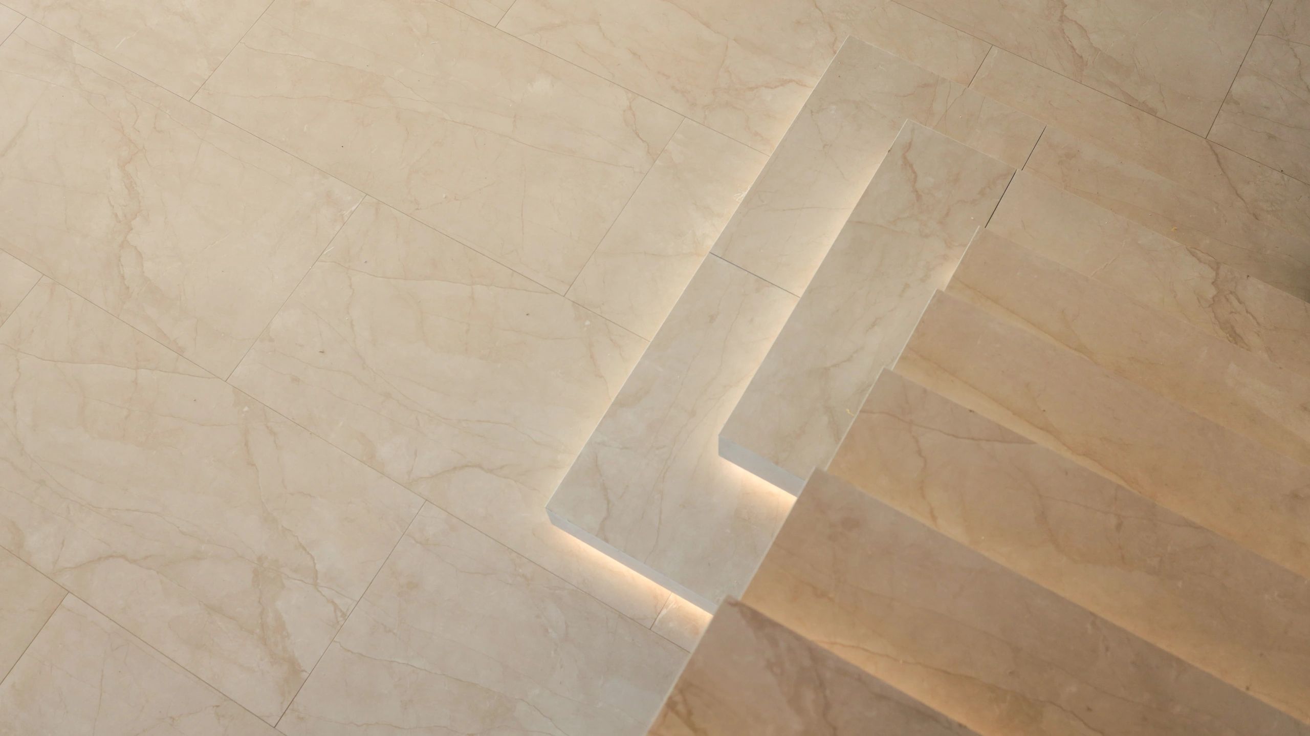 Modern staircase with integrated lighting and marble flooring